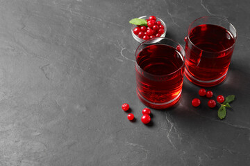 Tasty refreshing cranberry juice, mint and fresh berries on grey textured table. Space for text