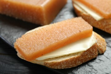 Tasty sandwich with quince paste on table, closeup