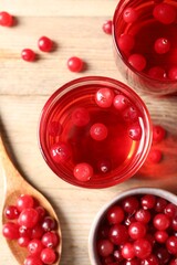 Tasty cranberry juice in glasses and fresh berries on wooden table, flat lay