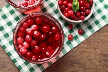 Tasty cranberry juice in glasses and fresh berries on wooden table, flat lay