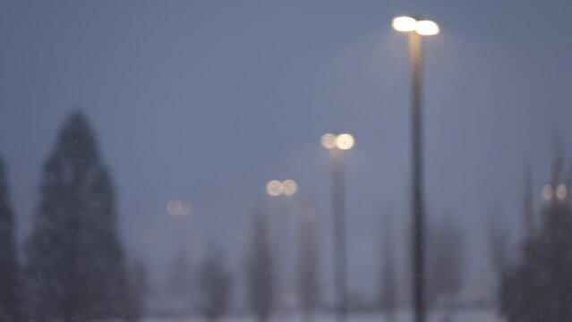 Purposefullly out of focus streetlights with heavy snowfall on a dark day