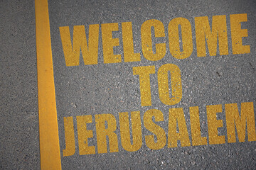 asphalt road with text welcome to Jerusalem near yellow line.