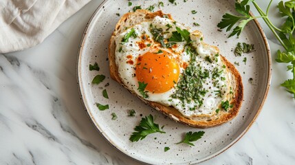  a white plate topped with a piece of bread covered in an egg on top of a piece of bread next to a sprig of green leafy parsley.
