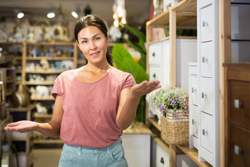 Portrait of attentive woman choosing dressing table in furniture store