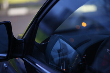 Close-up of a car's side mirror with a reflection of the dashboard, capturing the essence of...