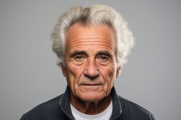 Portrait of an old man with grey hair. Isolated on grey background.