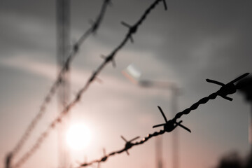 Close up of barbed wire against the sky