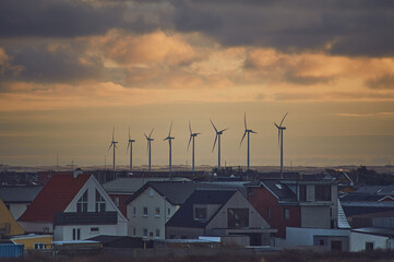 Wind energy next to village in denmark. High quality photo - 729674143