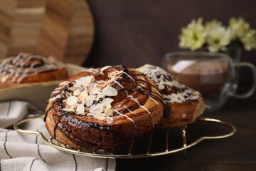 Delicious rolls with toppings and almond on wooden table, closeup. Sweet buns