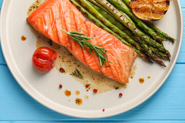 Tasty grilled salmon with tomato, asparagus and spices on table, top view