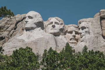 Close-up view of Mt. Rushmore, featuring the faces of four famous U.S. Presidents carved into the...