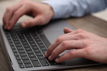 E-learning. Man using laptop during online lesson at table indoors, closeup