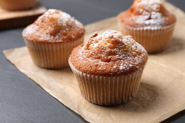 Delicious sweet muffins on black table, closeup