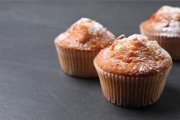 Delicious sweet muffins on black table, closeup. Space for text