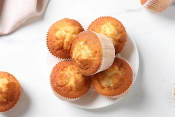 Delicious sweet muffins on white marble table, flat lay