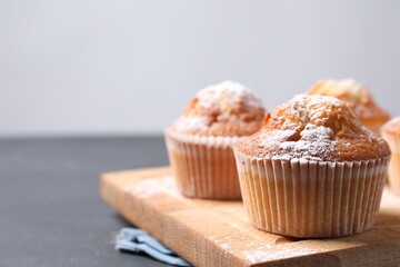 Delicious sweet muffins on black table, closeup. Space for text