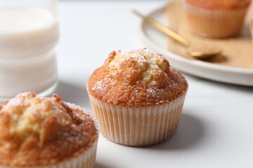 Delicious sweet muffins on white table, closeup