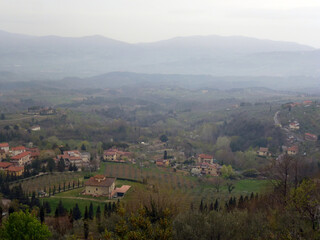 Villas and cottages are built along the valley. In the distance there are small hills under a blue sky