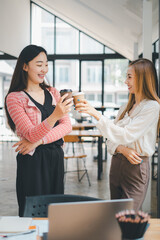 Business relax concept, Two professional women enjoying a friendly chat over coffee in a bright modern office space.