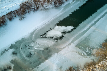 View of a freezing river at the beginning of winter, ice formation on the river from the air
