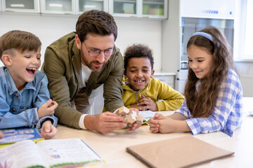 Teacher and children in a classroom, exploring a new topic in chemistry.