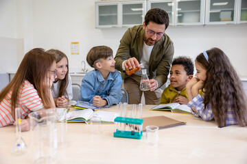 Teacher and children in a classroom, exploring a new topic in chemistry.