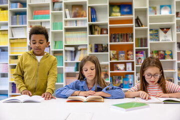 Group of kids sitting studying in elementary school library.