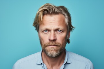 Portrait of a handsome mature man with a beard on a blue background