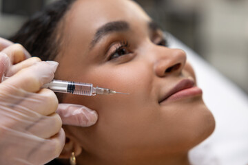 Young dark-skinned woman having a session of mesotherapy