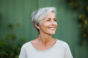 Fototapeta na wymiar Portrait of happy senior woman with grey hair smiling at camera outdoors