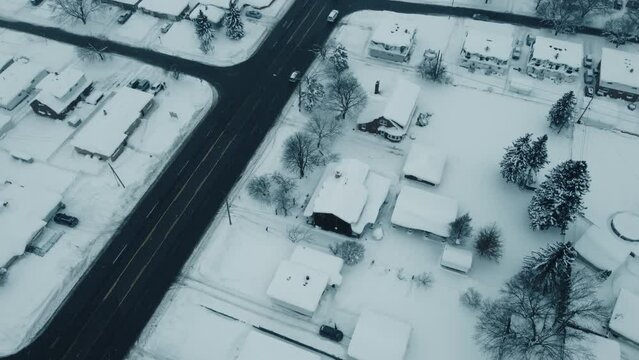 Flying over a snow-covered neighborhood during the middle of winter.