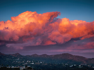 Massive red sunset clouds over Hollywood Hills mountains background. - 729690161