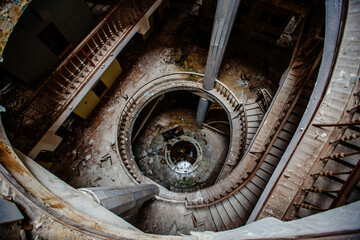 Top view of old vintage decorated spiral staircase in abandoned mansion - obrazy, fototapety, plakaty