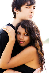 Young Attractive Couple Hugging Outdoors Woman Looking At Camera