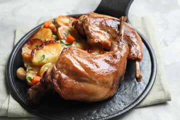 Tasty cooked rabbit meat with vegetables on table, closeup