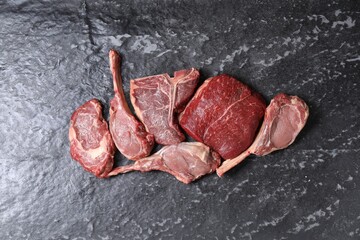 Fresh raw beef cuts on grey textured table, flat lay