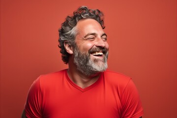 Portrait of a happy senior man laughing and looking away against red background