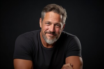 Portrait of a handsome mature man with gray beard on black background