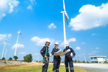 Engineers man and woman inspecting construction of WIND TURBINE FARM. WIND TURBINE with an energy...