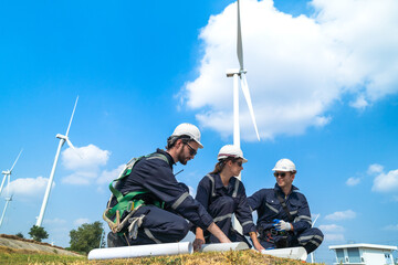 Engineers man and woman inspecting construction of WIND TURBINE FARM. WIND TURBINE with an energy...