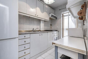 A small kitchen with antique white furniture, imitation granite countertops