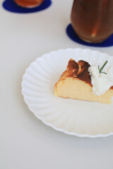 Basques Cheesecake with cream on white plate. A piece of cake on table in cafe. dessert. Fresh baked by homemade recipe.