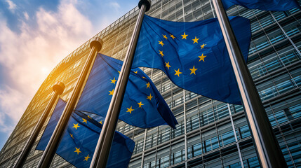 European flags in front of the Berlaymont building, headquarters of the European Commission in Brussels, Belgium at sunset