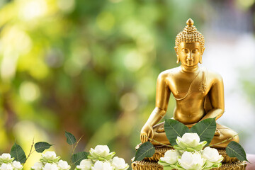 Buddha statue and lotus flowers on natural background.