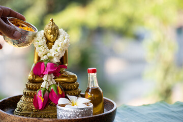 Sprinkle water onto buddha with water with flowers , thai traditional perfume and Jasmine garland...