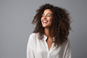 Portrait of a beautiful young african american woman laughing over grey background