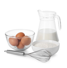 Metal whisk, raw eggs, flour and jug of milk isolated on white