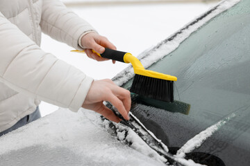 Man cleaning snow from car windshield outdoors, closeup - obrazy, fototapety, plakaty