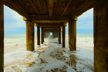 Waves under pier on Atlantic coast beach, Villa Gesell, Argentina, 02.01.2024