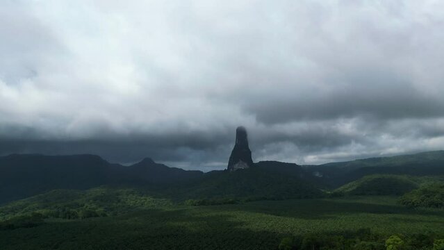 Drone rising toward the Pico Cao Grande mountain, gloomy day in Sao Tome, Africa